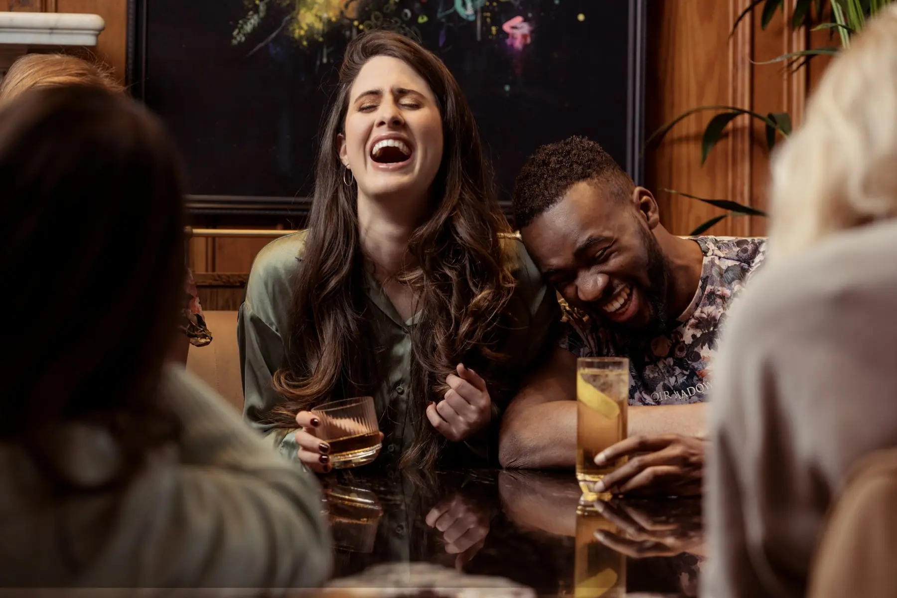 Amigos rindo juntos em volta de uma mesa